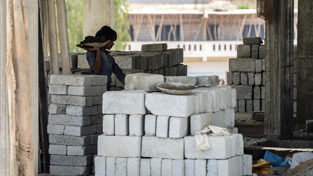 A boy works on a construction sites in Electronic City in Bangalore [Felix Gaedtke/Al Jazeera]