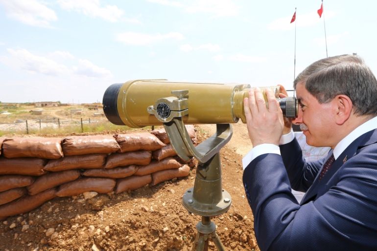 Turkish Prime Minister Ahmet Davutoglu looks through binoculars at Syria from a Turkish military base at the border with Syria [Reuters]