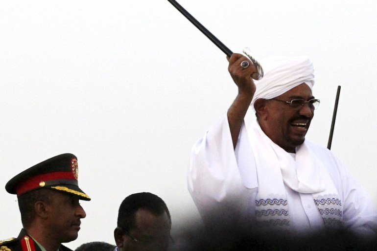 Sudanese President al-Bashir waves to his supporters at the airport in the capital Khartoum, Sudan