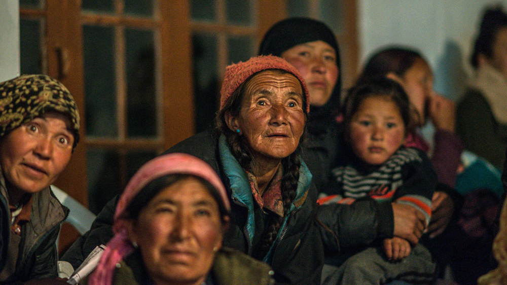 Villagers in Saspochey watch a film about the possible environmental impact of tourism during a village meeting set up by the Snow Leopard Conservancy India Trust. [Felix Gaedtke/NowHere Media /Al Jazeera] 
