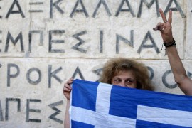 Anti-EU protesters hold Greek national flags on the Tomb of the Unknown Soldier in front of the parliament building during a demonstration of about five hundred people in Athens