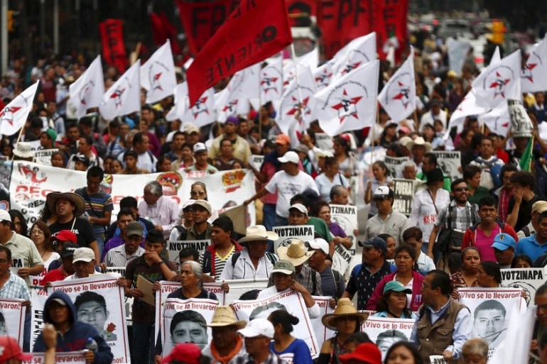 Demonstrators march during a protest to mark the nine-month anniversary of the Ayotzinapa students'' disappearance in Mexico City