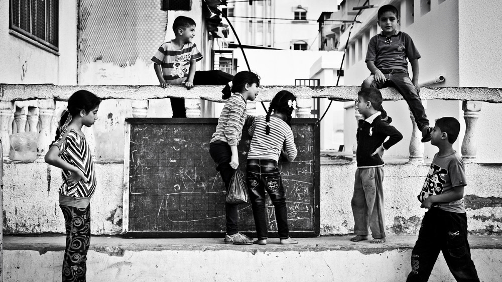 Shadia's children play with others in the courtyard of the school where they have been staying since their apartment was destroyed [Virginie Nguyen Hoang/Hanslucas/Collectif Huma] 