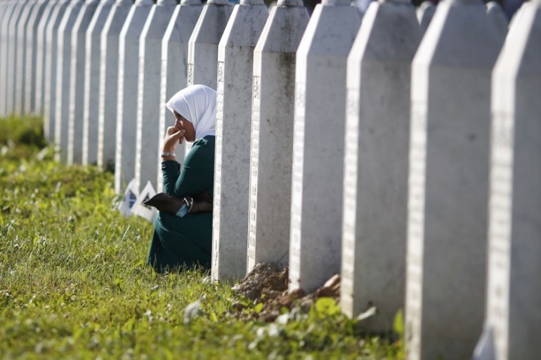 A woman mourns among graves in Memorial Center Potocari, near Srebenica