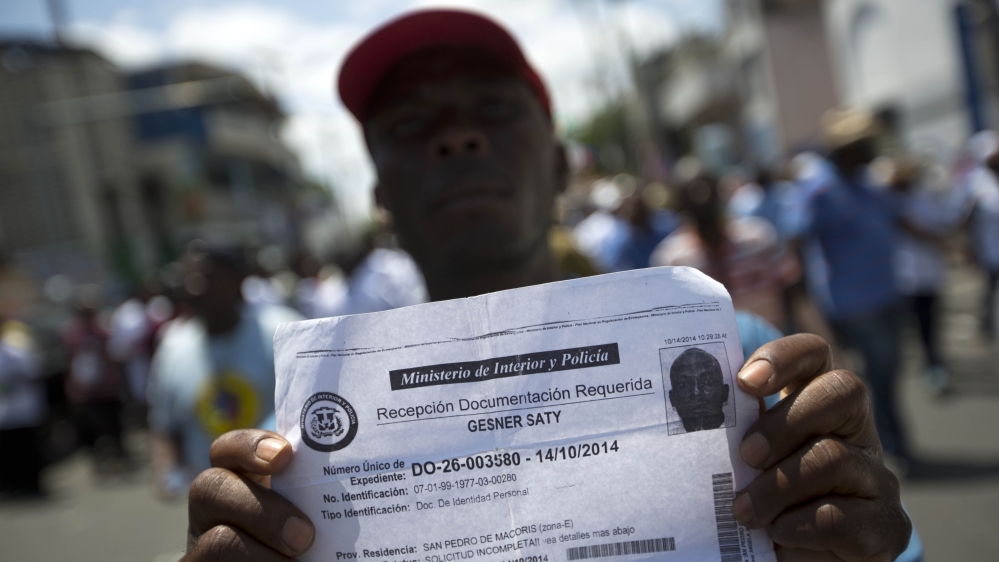 A deported Haitian man holds up a document that confirms he handed in paperwork to apply for legal residency in the Dominican Republic [AP]