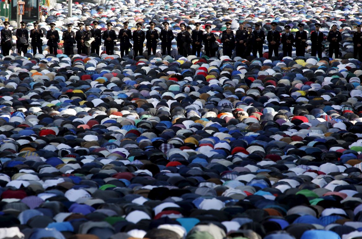 Interior Ministry members stand guard as Muslims attend the morning prayers of Eid al-Fitr holiday, marking the end of the holy month of Ramadan, in Moscow, Russia