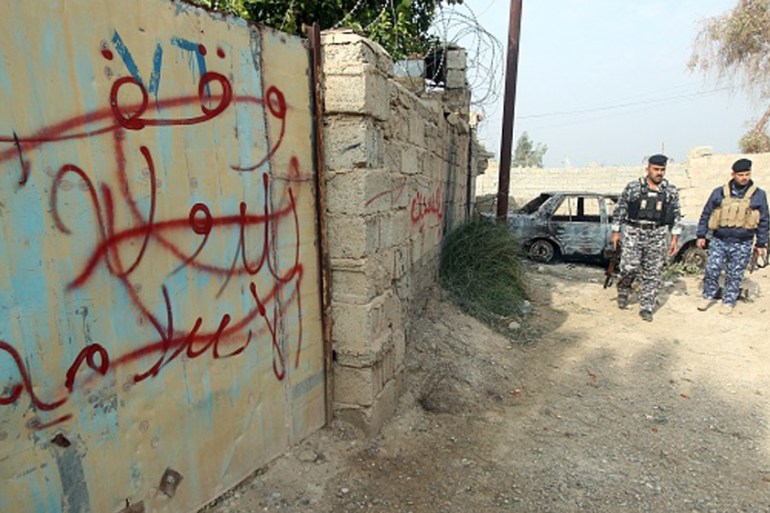 Iraqi policemen ISIL graffiti