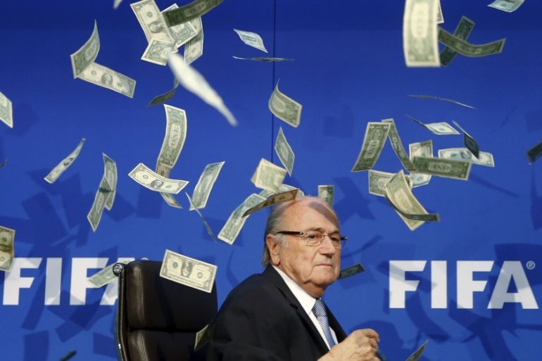 British comedian known as Lee Nelson (unseen) throws banknotes at FIFA President Blatter as he arrives for a news conference after the Extraordinary FIFA Executive Committee Meeting at the FIFA
