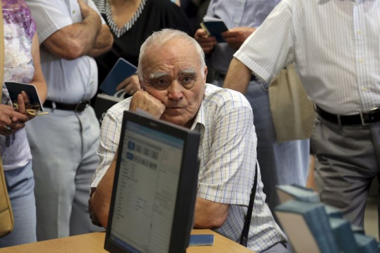 A pensioner waits to receive part of his pension inside a National Bank branch in Iraklio on the island of Crete