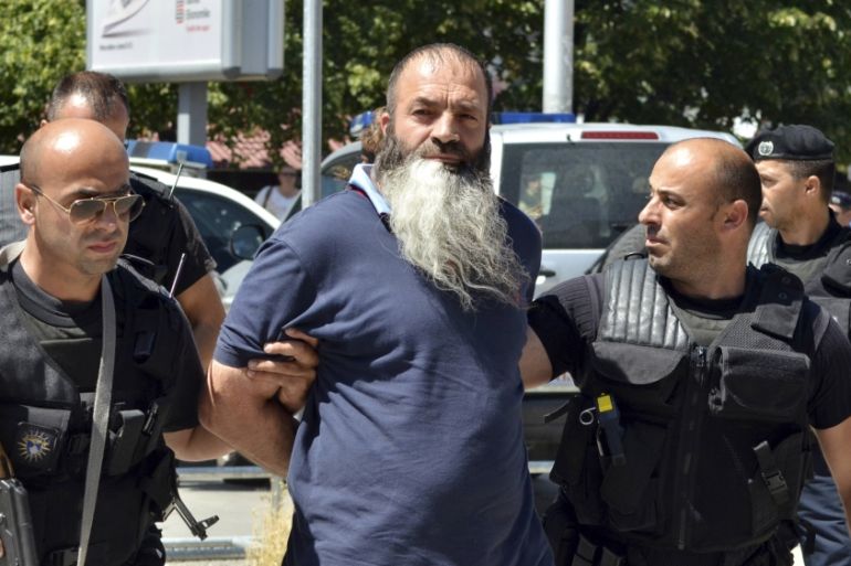 Kosovo police officers escort a man suspected of having fought with Islamist insurgents in Syria and Iraq as they arrive at a court in Pristina