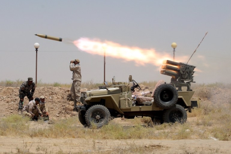 Members of Iraq''s Shi''ite paramilitaries launch a rocket towards Islamic State militants in the outskirts of the city of Falluja, in the province of Anbar