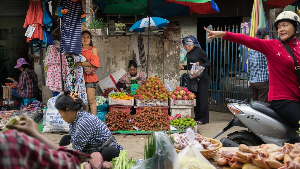 Champa buys fruit from a market stall near her house [Thomas Cristofoletti/Ruom]