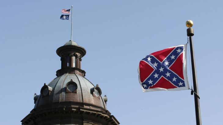 A confederate flag stands at the base of a confederate memorial in front of the South Carolina State House in Columbia