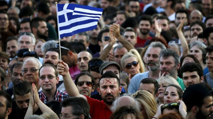 A protester sports the word ''No'' in Greek on his forehead as he waves a Greek flag during an anti-austerity demonstration in Syntagma Square in Athens