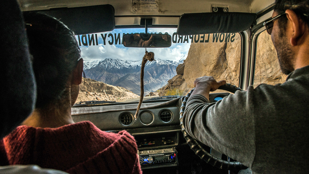The director of the Snow Leopard Conservancy India Trust (SLC-IT), a local NGO that works towards conservation of snow leopards,  Tsewang Namgail drives through mountain roads to reach remote populations [F  elix Gaedtke/NowHere Media /Al Jazeera]