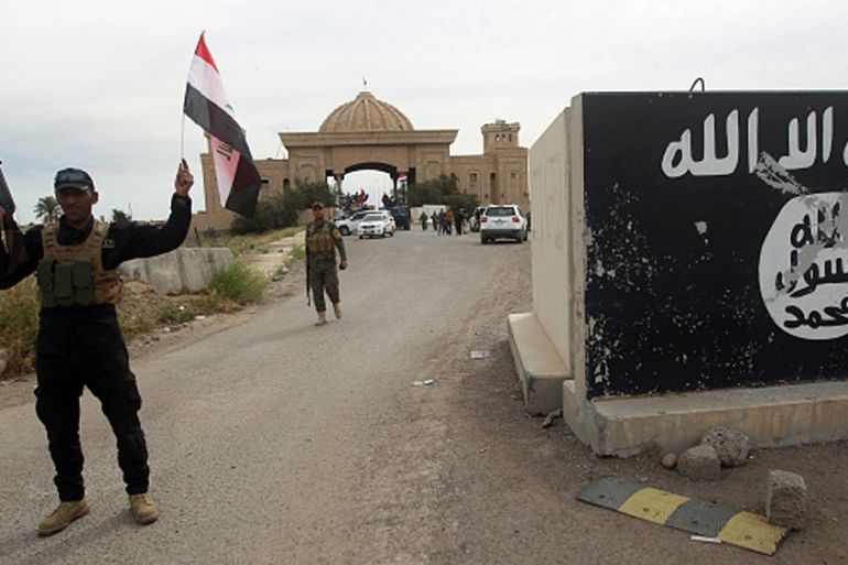 A mural depicting ISIL''s emblem outside one of the presidential palaces in Tikrit [Getty]