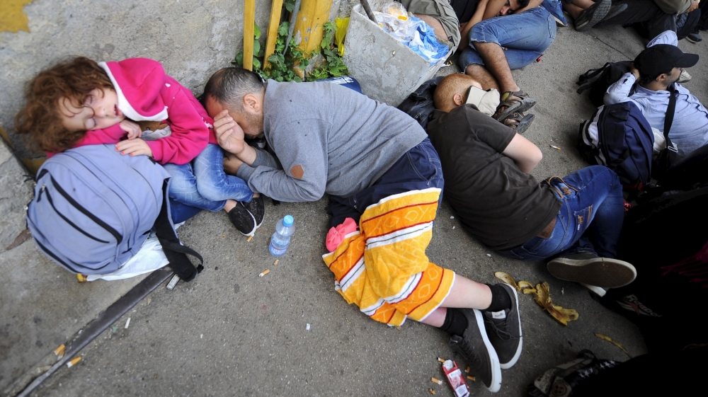 Refugees who made it through police blockades rest at the Gevgelija railway station in Macedonia [Reuters]