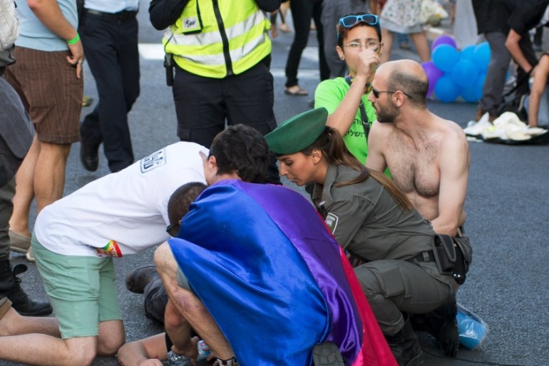 A participant of an annual gay pride parade is treated after an Orthodox Jewish assailant stabbed and injured six participants in Jerusalem on Thursday, police and witnesses said