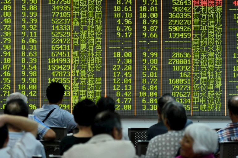 Investors look at stock information on an electronic board at a brokerage house in Hangzhou