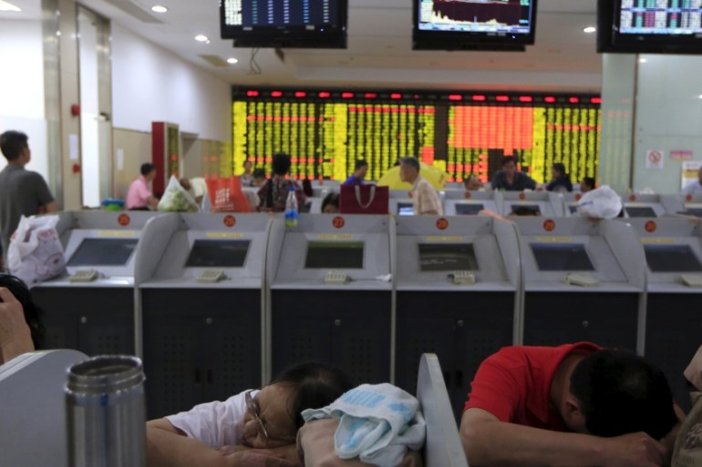 Investors rest in front at computer screens at a brokerage in Shanghai