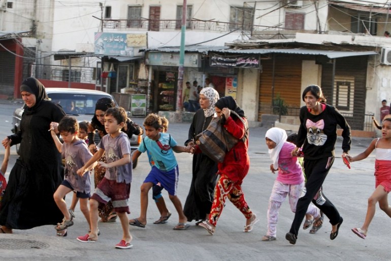 Palestinian residents flee Ain al-Hilweh Palestinian refugee camp, due to clashes in the area, near the port-city of Sidon, southern Lebanon