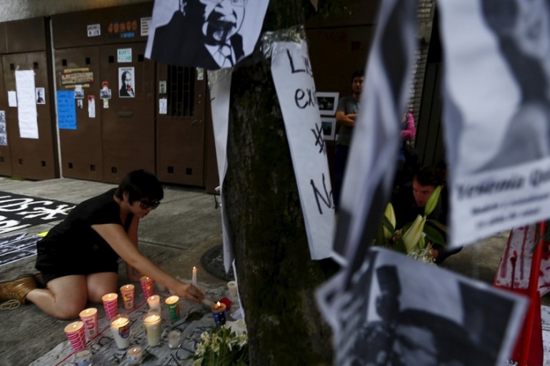 A demonstrator lights candles during a demonstration against the murder of photojournalist Ruben Espinosa and four other women outside the building where the bodies were found in Mexico City