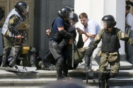 Ukrainian servicemen carry an injured comrade away from the parliament building in Kiev, Ukraine