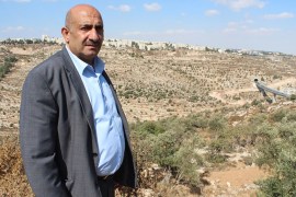 Beit Jala mayor Nicola Khamis in the Cremisan Valley, with Gilo settlement in the background