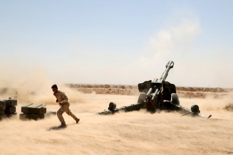 Iraqi security forces fire artillery during clashes with Islamic State militants on the outskirts of Anbar province