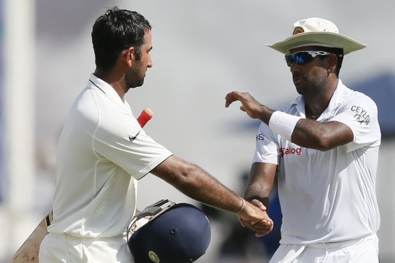 India''s Pujara is congratulated by Sri Lanka''s fast bowler Prasad for scoring a century during the second day of their third and final test cricket match in Colombo