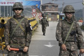 A South Korean army soldier walks as his colleague soldiers stand guard on Unification Bridge, which leads to the demilitarized zone, near the border village of Panmunjom in Paju, South Korea [AP]