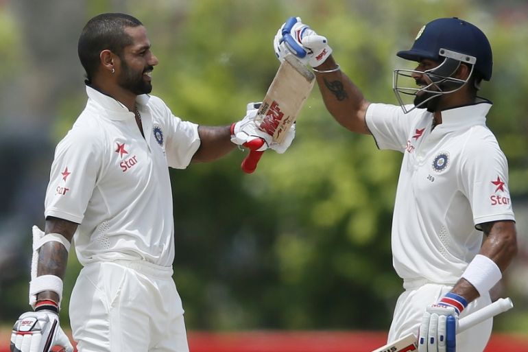 India''s Dhawan celebrates his century with team captain Kohli during the second day of their first test cricket match against Sri Lanka in Galle