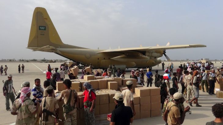 Workers and Southern Resistance fighters unload aid shipment from a Saudi military cargo plane at the international airport of Yemen''s southern port city of Aden