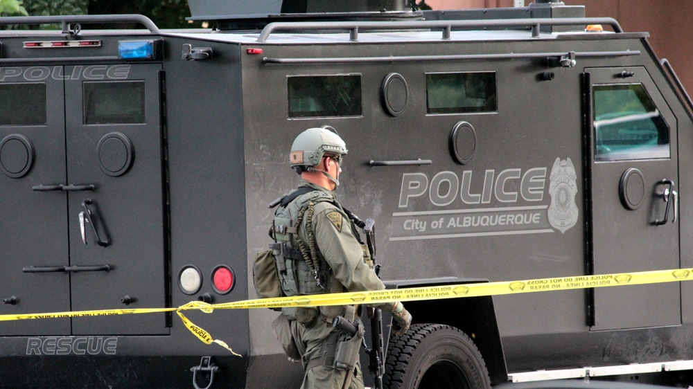 
A member of Albuquerque's SWAT team retrieves gear from the department's Bearcat armoured vehicle during a SWAT standoff with a mentally-ill man in June 2015 [Andy Beale/Al Jazeera]
