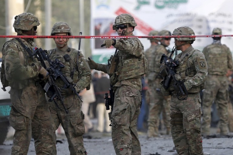 NATO soldiers keep watch at the site of a car bomb blast in Kabul, Afghanistan