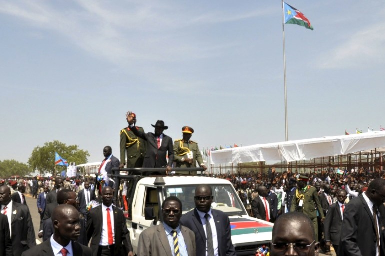 South Sudan''s President Salva Kiir waves to the crowd atop a truck as he arrives at John Garang''s Mausoleum to celebrate the 4th Independence Day in Juba