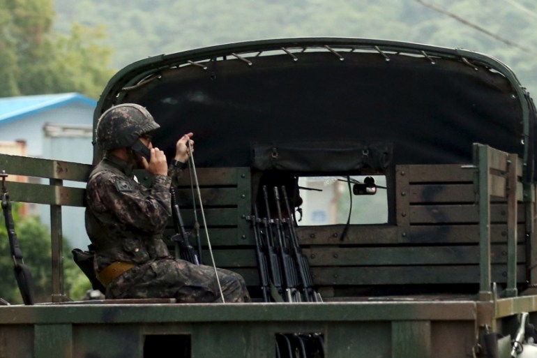 A South Korean soldier talks on a radio as he sits on a military vehicle at the demilitarized zone separating the two Koreas in Yeoncheon