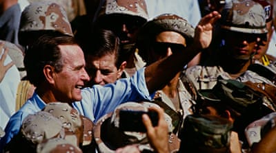 George H W Bush celebrates Thanksgiving with the US Marines in Saudi Arabia, during the Gulf War [Getty]