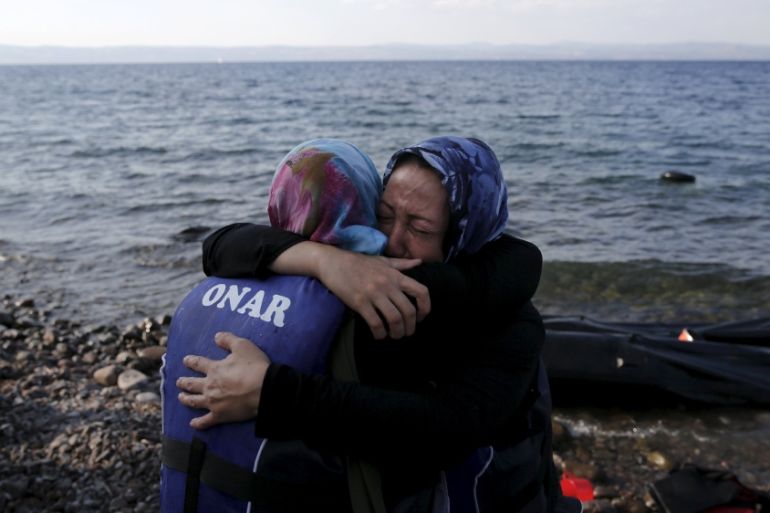 Two Afghan migrant women hug, moments after they arrived on a dinghy on the island of Lesbos