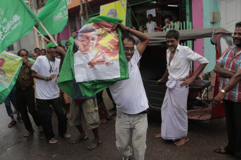 Supporters of Sri Lanka''s ruling United National Party carry a portrait of prime minister