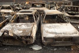 Cars burnt by the Chelan Complex fire are seen at a junkyard that was overcome by flames in Chelan, Washington