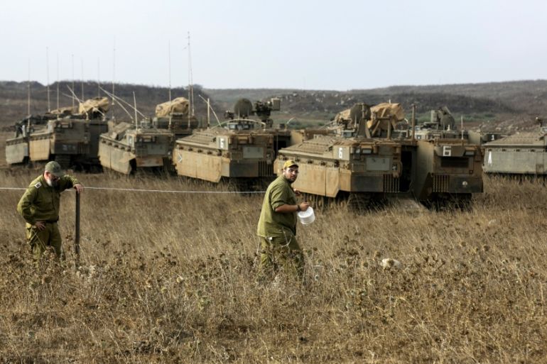 Israeli soldiers demarcate an area as they stand near armoured personnel carriers during an exercise in the Israeli-occupied Golan Heights, near the ceasefire line between Israel and Syria