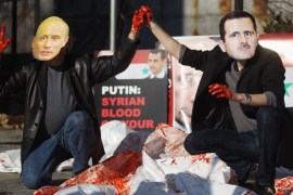 Actors wearing masks of Assad and Putin perform with body bags during a demonstration outside United Nations headquarters in 2011 [Getty]