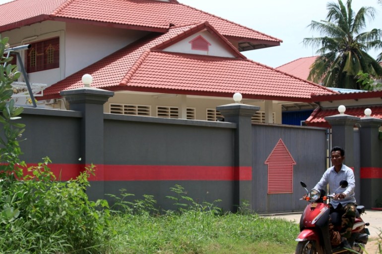 Women ride a motorcycle past a house that is used to temporarily house asylum seekers sent from a South Pacific detention centre, in Phnom Penh, Cambodia