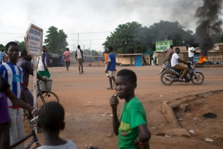 Anti-coup protesters stand next to burning tires in Ouagadougou