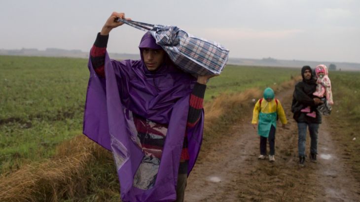 Migrants walk on a field, after they crossed the border with Serbia, near Tovarnik, Croatia