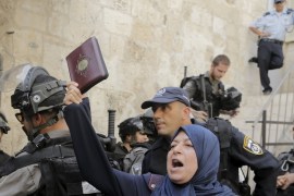 A Palestinian woman shouts slogans as she holds a Koran during clashes with Israeli police forces in Jerusalem''s Old City