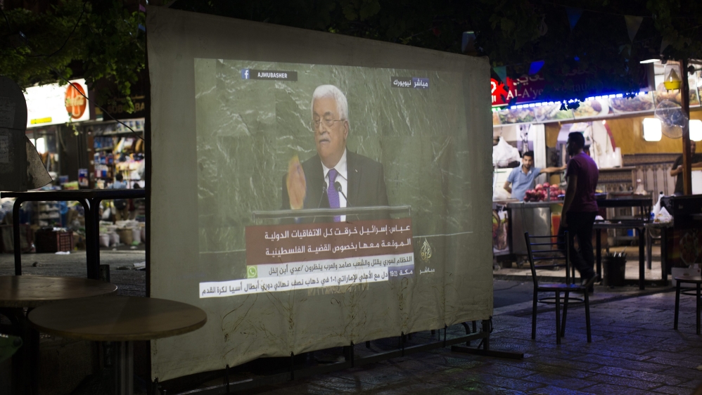 Palestinians watch PA President Mahmoud Abbas' speech to the UNGA on a large screen in East Jerusalem, the site of several clashes between Palestinians and Israeli forces in recent weeks [EPA]