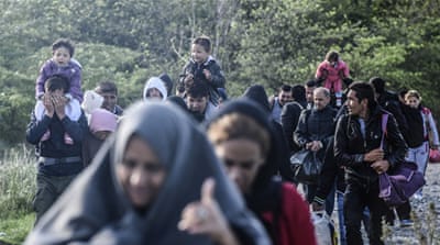 Migrants and refugees walk towards a registration camp after crossing the Macedonian-Greek border [AFP]