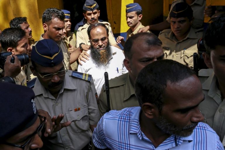 Two of the 12 men, convicted of planning several blasts on crowded commuter trains in the financial capital of Mumbai in 2006, is escorted by police to a court in Mumbai